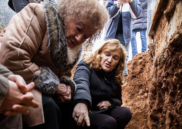 Milagros y su hija Pilar contemplan los restos mortales de Vicenta en la fosa anónima donde fue enterrada sobre su hijo Jesús / ARMH