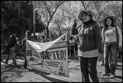 Maestros de Oaxaca marchan en protesta con los sindicatos independientes hacia la plaza principal de la Ciudad de México, el zócalo, en el 20 aniversario de la entrada en vigor del Tratado de Libre Comercio de América del Norte (2014). Los manifestantes portan una manta que dice: “No a la reforma educativa del gobierno federal”, y “Sí a la PTEO, la reforma educativa del sindicato de maestros en Oaxaca”.