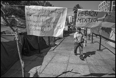 Maestros de Oaxaca y otros estados levantan una tienda de campaña (plantón) para protestar contra la aprobación de la reforma educativa por el gobierno mexicano y el Partido Revolucionario Institucional. Algunos de los profesores que protestan vivieron por meses en el plantón de Plaza de la República, próxima al Monumento a la Revolución, antes de ser desalojados por la policía. Algunos de los carteles revelan que vienen de la Mixteca oaxaqueña.