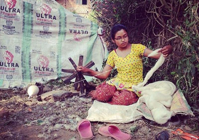 Sulochana Maharjan, de 16 años, hila lana en Chapagaon, Nepal. Ella y su familia estaban durmiendo en una tienda de campaña próxima a su casa, sin saber si su hogar era seguro para quedarse después del sismo. En medio de las ruinas y la pena, la vida sigue. 