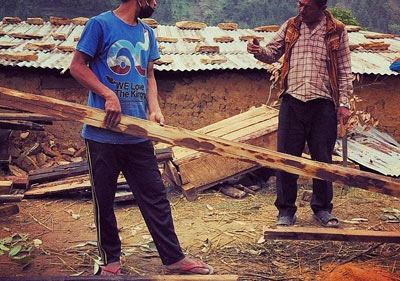 Sikrighyang, Nepal. Mann Bahadur pregunta a Bilong sobre las dimensiones de la madera requerida para la armazón de su casa. Bilong de 31 años, es de India y tiene unos siete años de experiencia en construir casa de bambú. A pesar de su diferencia lingüística, se entienden bien uno al otro y están trabajando juntos para construir la casa de Mann Bahadur que fue destruida por el terremoto. 